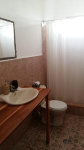 y baño con lavabo, aseo y espejo. en Mambo Ecohostal, en San Lorenzo