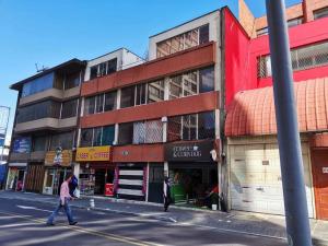 dos personas cruzando una calle frente a un edificio en Suite Ejecutiva, en Quito