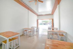 Habitación con mesas, sillas y ventilador de techo. en SUPER OYO 90457 Anara Residence & Guest House, en Medan
