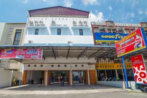 a large white building with signs in front of it at SUPER OYO 90457 Anara Residence & Guest House in Medan