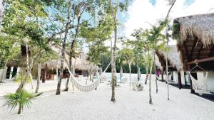 a resort with a hammock in the middle of trees at Magic Xcacel Tulum in Chemuyil