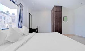 Un dormitorio con una gran cama blanca y una ventana en FabHotel Skyry en Chennai