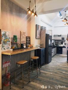 a kitchen with a counter and two stools at 曬日子宿物所Sundays BnB 包棟民宿 in Huxi