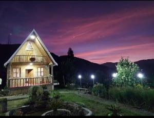 una casa con luces encendidas en un campo por la noche en Spring Brooks Homestay en Darjeeling