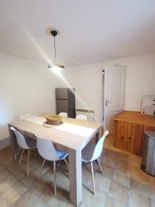 a dining room with a wooden table and chairs at Appartement Lauzet-Ubaye in Le Lauzet-Ubaye +5 photos