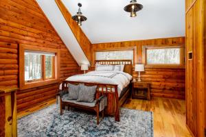 um quarto num chalé de madeira com uma cama e uma cadeira em Queens Birch Lodge em Eagle River