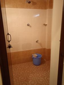 a bathroom with a shower with a bucket in it at Paradise corner in Puducherry