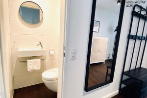 a bathroom with a white toilet and a mirror at Haus Lieke Deeler in Norderney