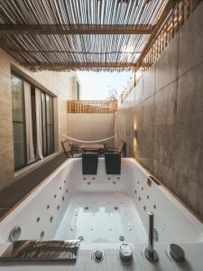 eine Badewanne mit zwei Stühlen im Bad in der Unterkunft Riad Dar Al Rumman in Qurayyah