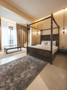 a bedroom with a four poster bed and a rug at Riad Dar Al Rumman in Qurayyah