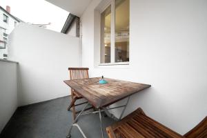uma mesa de madeira e cadeiras num quarto com uma janela em Apartment Blue - Zentral und gut angebunden em Dusseldorf