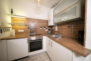 uma cozinha com armários brancos e um balcão de madeira em Apartment Blue - Zentral und gut angebunden em Dusseldorf
