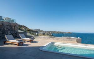 a swimming pool on a patio with a view of the ocean at Ligaria Mare in Agia Pelagia