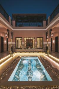 an indoor pool in a building with a swimming pool at Riad Dar Al Rumman in Qurayyah