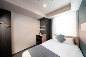 a bedroom with a bed and a dresser at KOKO HOTEL Tsukiji Ginza in Tokyo