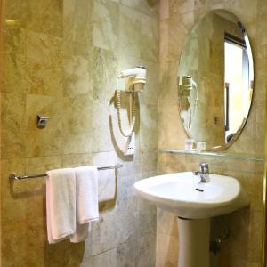 a bathroom with a sink and a mirror at Jakarta Airport Hotel in Tangerang