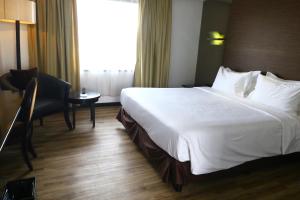 a hotel room with a large white bed and a desk at Jakarta Airport Hotel in Tangerang