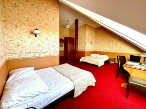 a bedroom with two beds and a desk with a computer at Pańska Góra in Jaworzno