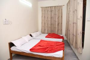 - une chambre avec 2 lits et des draps rouges dans l'établissement Hotel Yash Paradise 6 Min Distance from Dargah, à Kokkíni Khánion