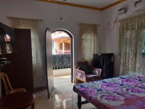 BardezにあるMaria guest houseのベッドルーム1室(ベッド1台、鏡、椅子付)