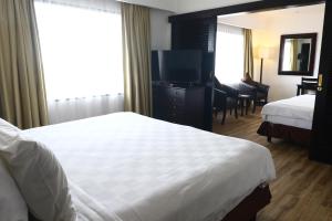 a hotel room with a bed and a television at Jakarta Airport Hotel in Tangerang