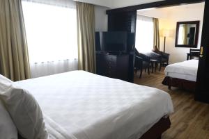 タンゲランにあるJakarta Airport Hotelのベッドとテレビが備わるホテルルームです。
