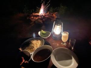un tavolo con due ciotole di cibo e un fuoco di Chalet in the Jungle a Kaduwela