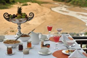 a table with a bowl of fruit and a bowl of food at Karongwe Portfolio - Kuname Lodge in Hoedspruit