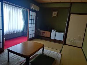 Iizukaあけぼの館的带桌子和窗户的客厅