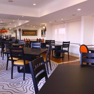 ein Esszimmer mit Tischen und Stühlen in der Unterkunft Jakarta Airport Hotel in Tangerang