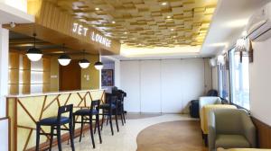 a bar in a waiting room with chairs and tables at Jakarta Airport Hotel in Tangerang