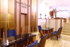 a lobby with blue chairs and a table and stairs at Jakarta Airport Hotel in Tangerang