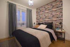 um quarto com uma cama grande e uma parede de tijolos em Modern 2 bed Apartment- Town Centre em Northampton