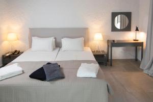 a bedroom with a large bed with two towels on it at Apollo Resort in Agia Marina Aegina