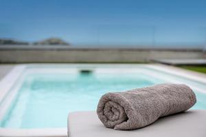a towel sitting on a table in front of a swimming pool at Ligaria Mare in Agia Pelagia