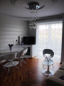 - un salon avec une table, des chaises et un canapé dans l'établissement Apartament Lawendowy, à Jastrzębia Góra