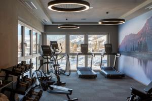 a gym with cardio machines and a large window at PURE Resort Westendorf in Westendorf