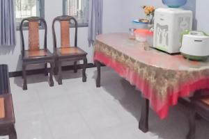 einem Tisch mit zwei Stühlen und einem weißen Gerät darauf in der Unterkunft TRIYOGA Homestay Syariah RedPartner in Sangkanurip
