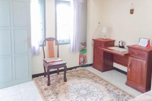 ein Badezimmer mit einem Stuhl, einem Schreibtisch und einem Waschbecken in der Unterkunft TRIYOGA Homestay Syariah RedPartner in Sangkanurip