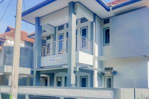 un edificio azul y blanco con balcón en TRIYOGA Homestay Syariah RedPartner, en Sangkanurip