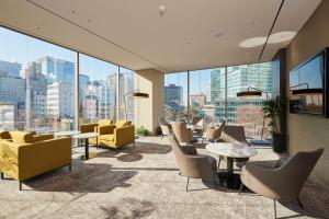 eine Lobby mit Stühlen, Tischen und Fenstern in der Unterkunft Nine Tree Premier Hotel Insadong Myeongdong in Seoul