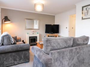 a living room with two couches and a tv at Arnside House in Carnforth