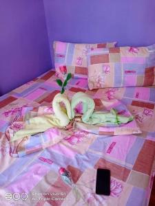 a bed with swans laying on top of it at Purple Guesthouse in Nasugbu +73 photos