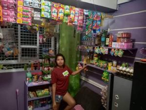 a young girl is standing in a store at Purple Guesthouse in Nasugbu