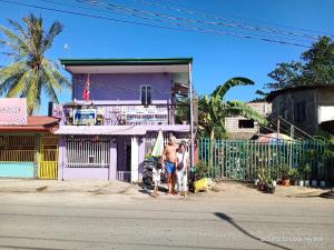 two men standing in front of a purple house at Purple Guesthouse in Nasugbu