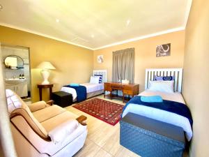 a hotel room with two beds and a couch at Country Lane Farm lodge in Cradock