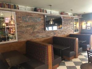een restaurant met 2 stoelen en een bakstenen muur bij Scone Arms Hotel in New Scone