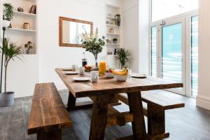 uma sala de jantar com uma mesa de madeira e bancos em Seascape em Penzance