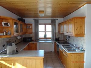 Röttenbach的住宿－Ferienwohnung Schwarz，一个带木制橱柜和窗户的大厨房