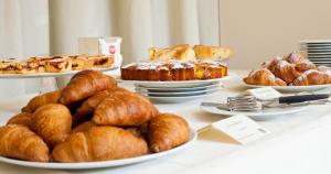 un tavolo con piatti di croissant e prodotti da forno di Hotel Mamiani & Kì-Spa Urbino a Urbino